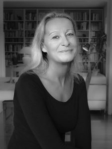 Abbildung einer Frau mit blonden langen Jahr in schwarz/weiß, zu sehen ist die Autorin Kristina Stella